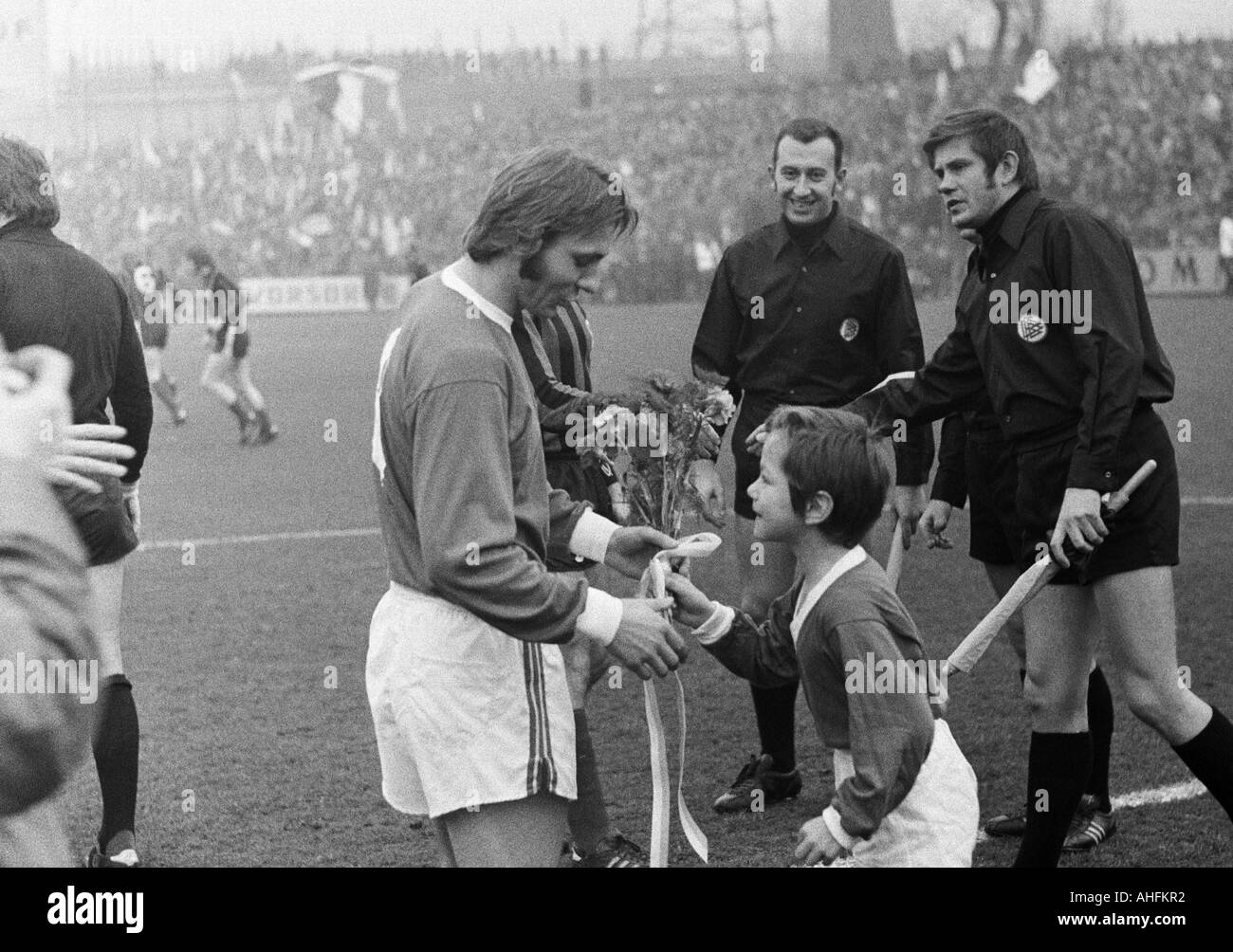 Football, Bundesliga, 1971/1972, Glueckaufkampfbahn Stadium à Gelsenkirchen, le FC Schalke 04 contre Hanovre 96 5:0, joueur de football, honneur de Reinhard Libuda (S04), un joueur de l'équipe de jeunes lui présente un bouquet de fleurs, derrière les officiels de match Banque D'Images