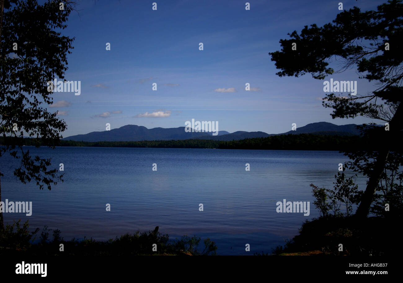 Lac Clair dans les montagnes Adirondack avec arbres premier plan en silhouette Banque D'Images