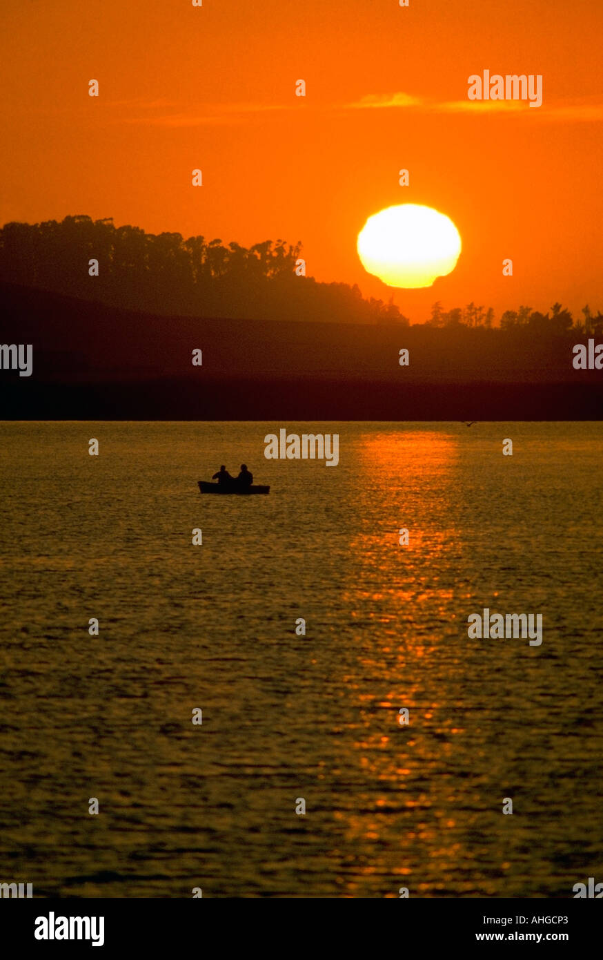 Deux pêcheurs sur un bateau de tenter leur chance dans un lac au coucher du soleil de la côte centrale de Californie Banque D'Images