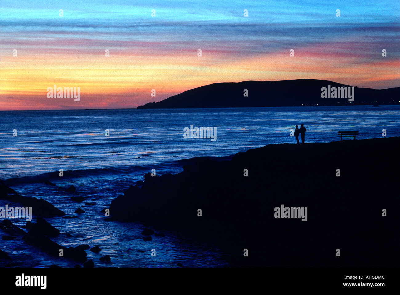 Un couple se tenir sur un belvédère en regardant un coucher de soleil près de Pismo Beach, en Californie. Banque D'Images