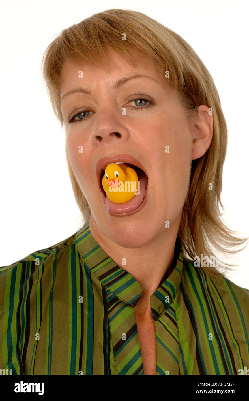 Femme avec un canard en plastique sur sa langue Banque D'Images