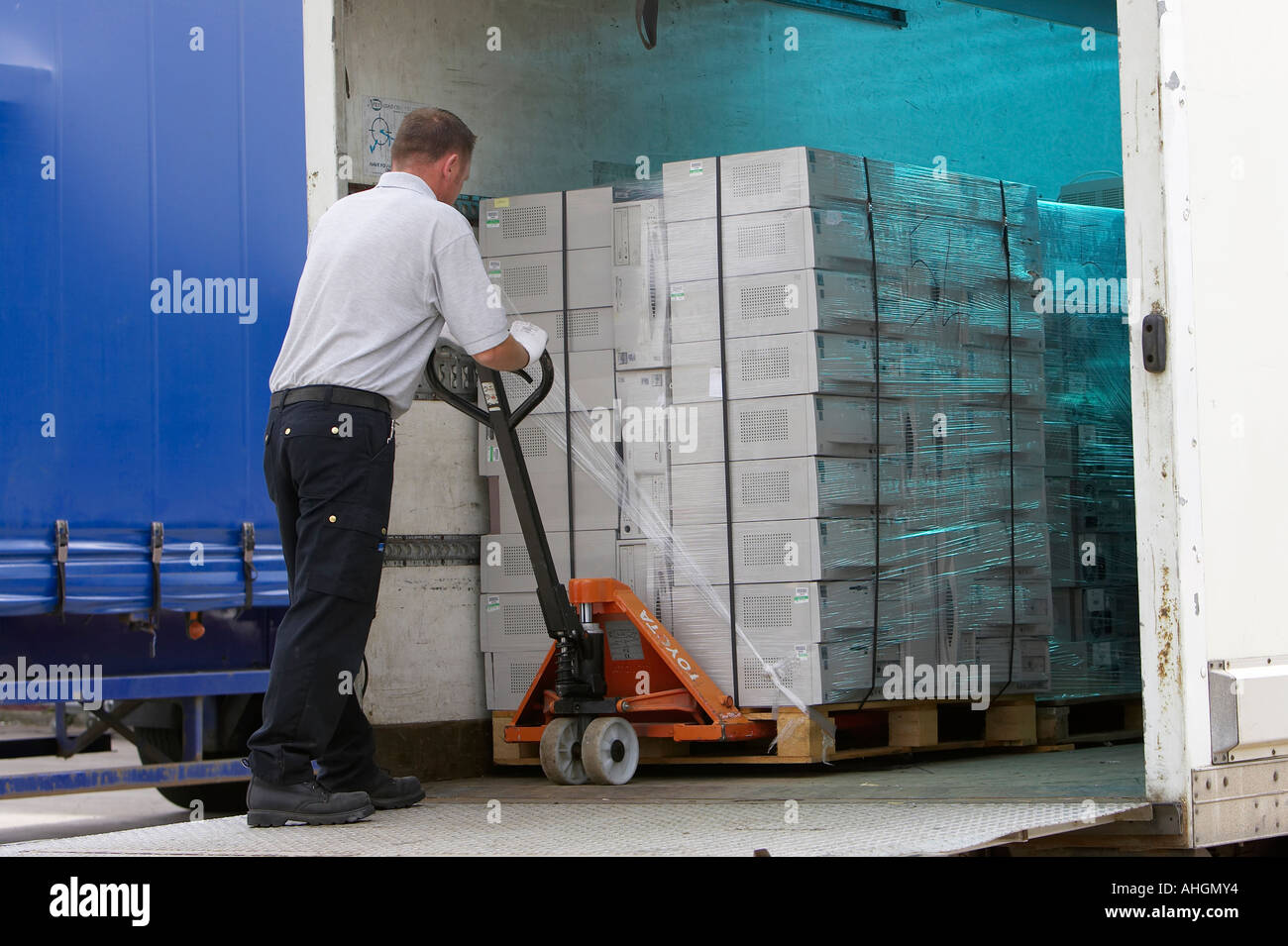 Ouvriers déchargement camion plateau élévateur contenant palette enveloppée  des piles de boîtes de système informatique pour le nettoyage des données  et de recyclage Photo Stock - Alamy
