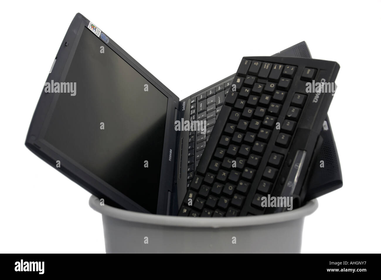 Clavier ordinateur portable et entassés dans des bacs en plastique gris sur un fond blanc. Banque D'Images
