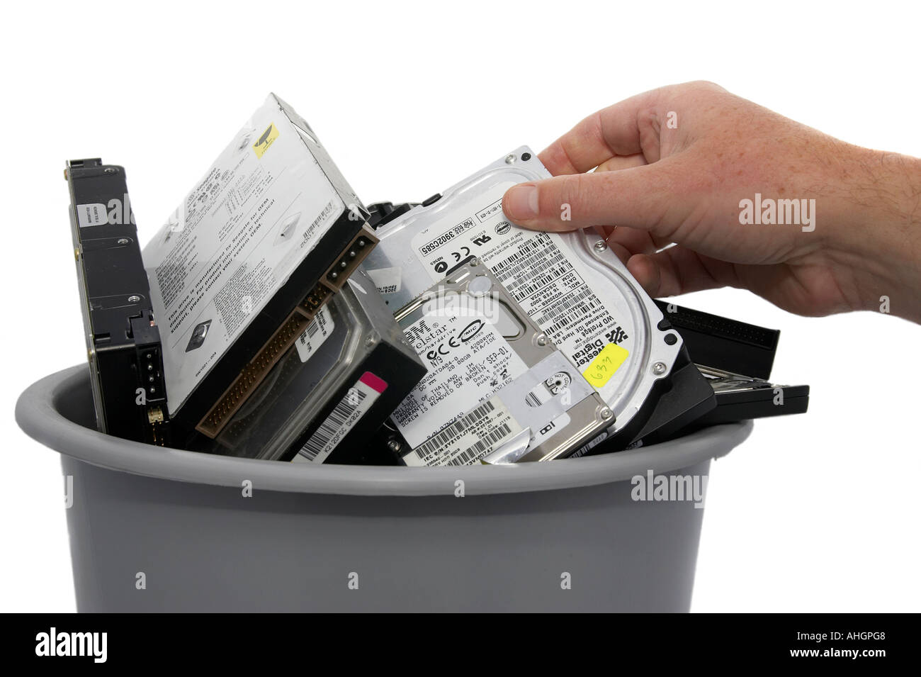 La suppression de la main ou de placer les disque dur dans le bac gris contenant divers les disques durs des ordinateurs contre fond blanc Banque D'Images
