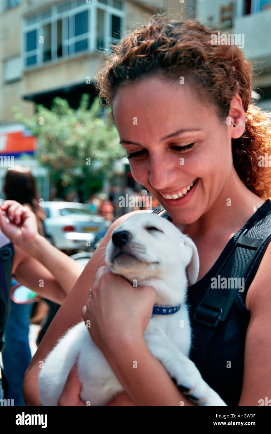 Israël Tel Aviv une femme à un jeune chiot à affectueusement Banque D'Images