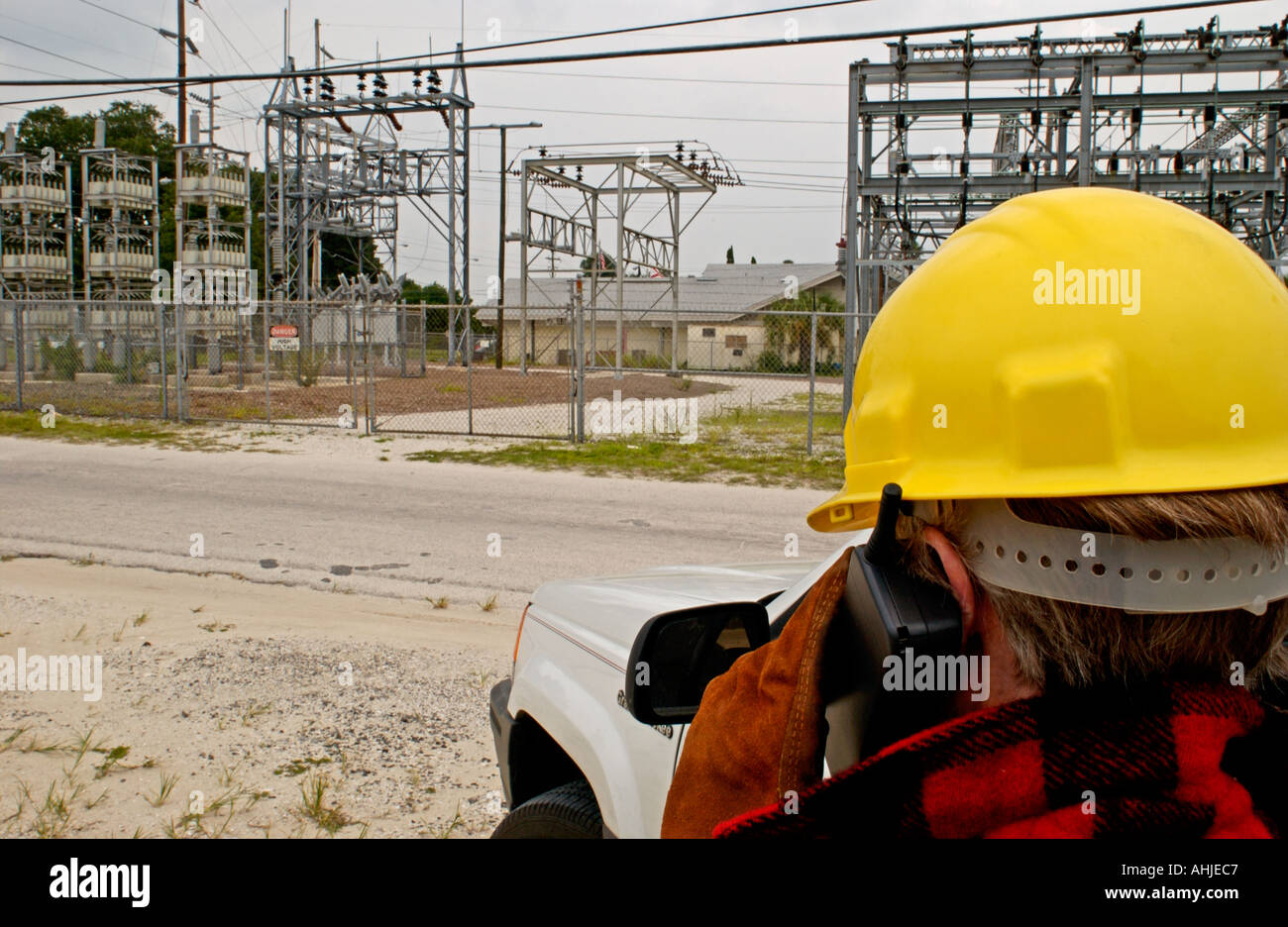 Entrepreneur en électricité avec téléphone cellulaire à une sous-station power company Banque D'Images