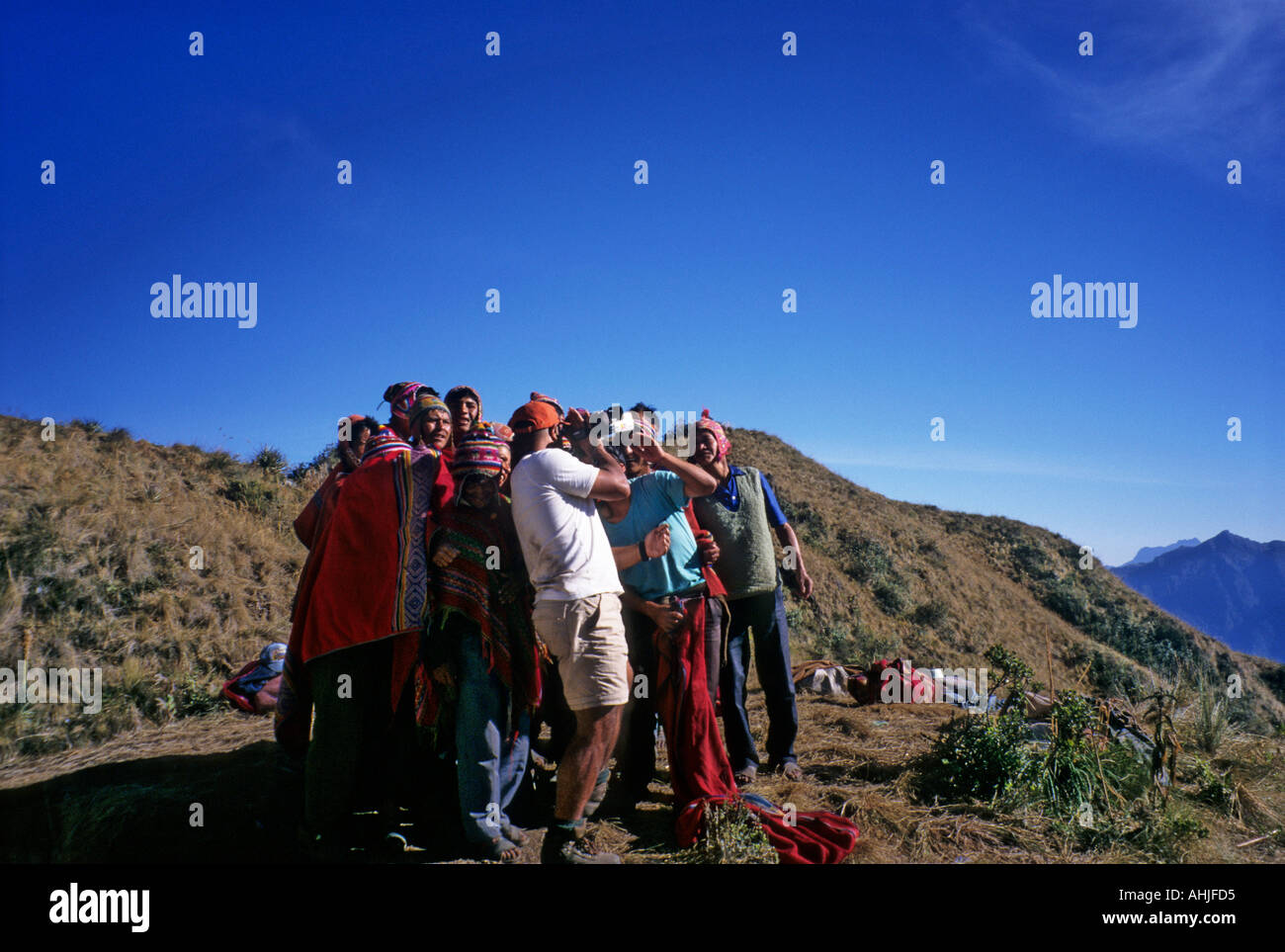 Groupe de porteurs se rassemble autour de regarder la lecture sur la videocamera touristique au camping Phuyupatamarca. Inca Trail, Pérou. Banque D'Images