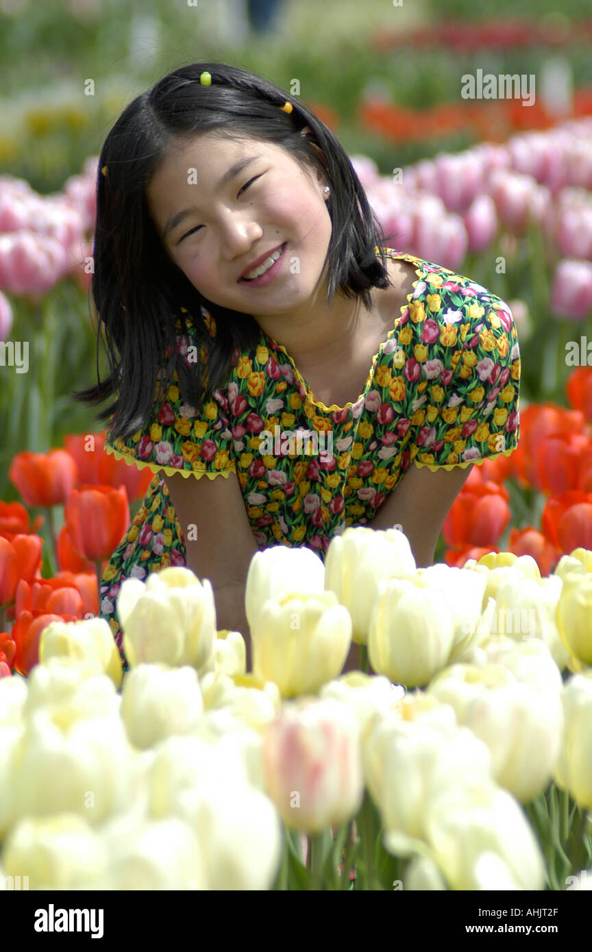 11 ans fille asiatique en robe à fleurs avec des tulipes tulipes Veldheer pose à la ferme des tulipes en Hollande au Michigan USA 2 Banque D'Images