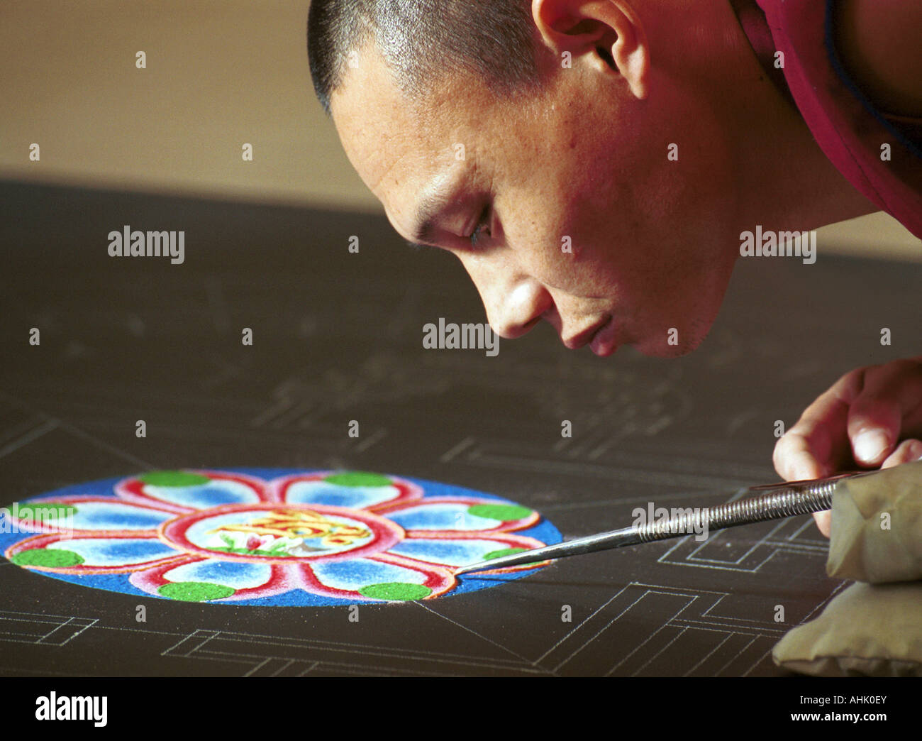 Moine tibétain travaillant sur une fresque de sable mandala Banque D'Images