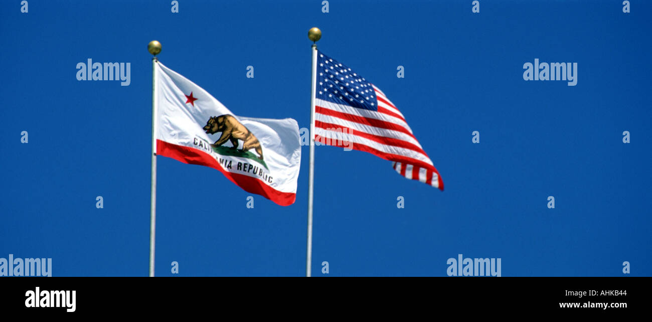 United States et California State flags flying against clear blue sky Banque D'Images