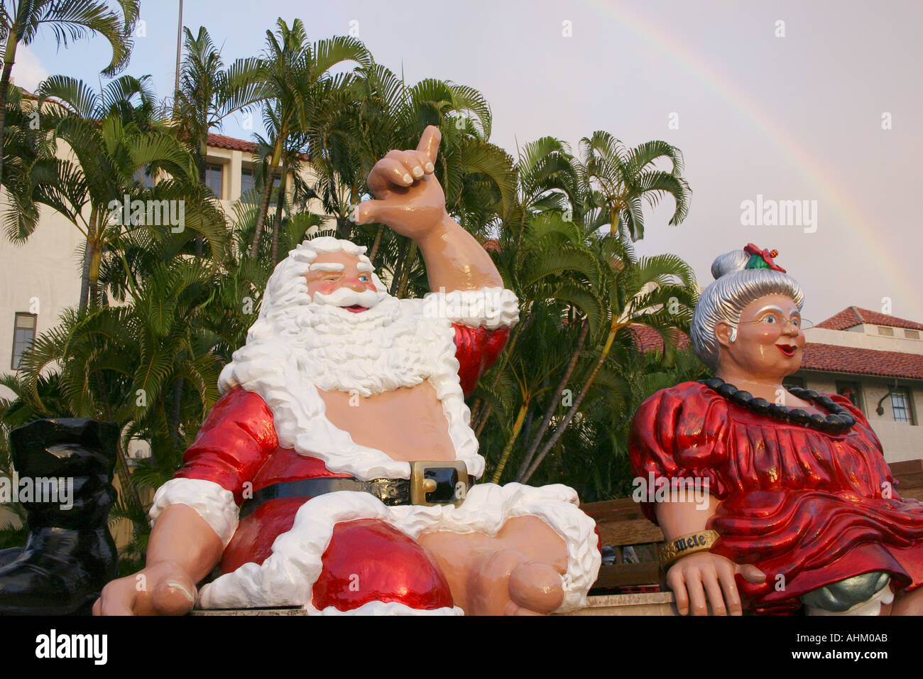 Père Noël hawaïen et Mme Claus au sommet d'une fontaine avec rainbow à Honolulu Hawaii Banque D'Images