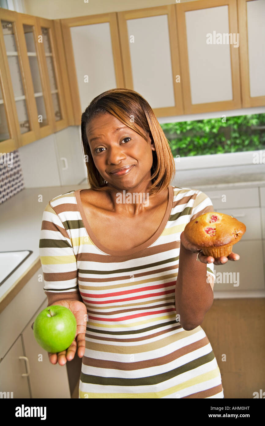 African woman holding apple et un muffin Banque D'Images African woman holding apple et un muffin Banque D'Images