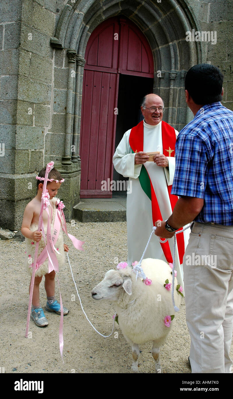 Un prêtre se félicitant de 4 ans, Hugo, ses moutons et son grand-père pour l'église de la Feuillée la masse Pardon annuel Banque D'Images
