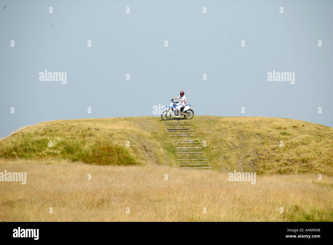 Équitation de moto hors route de manière illégale sur le haut de l'âge de fer Fort Twmbarlwm South East Wales UK Banque D'Images