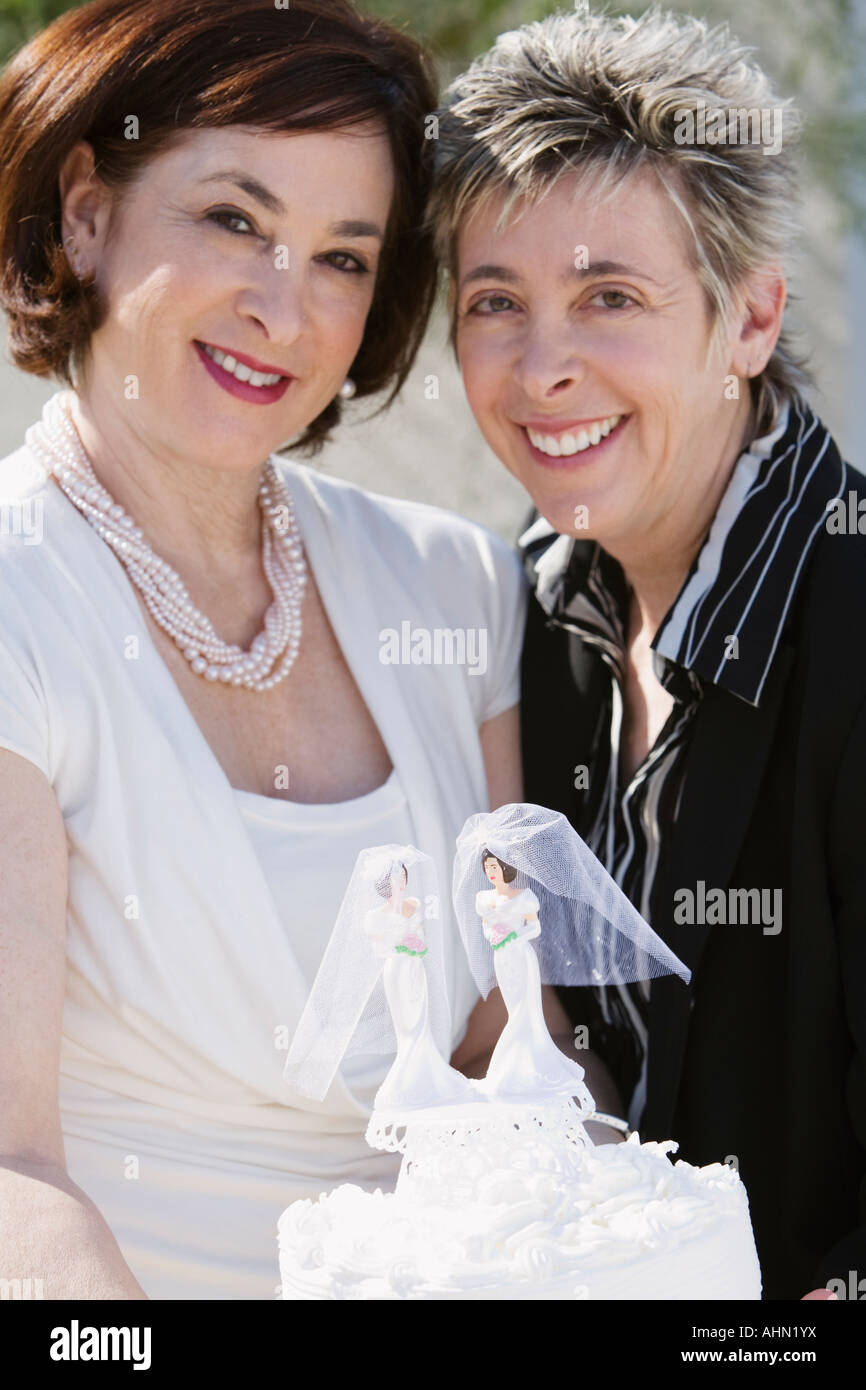 Newlywed couple de lesbiennes affichant leur gâteau de mariage Banque D'Images