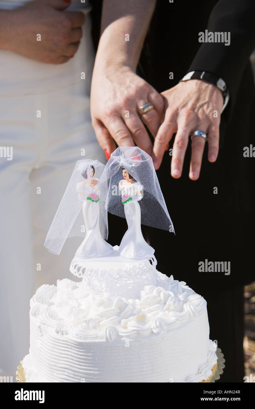 Newlywed couple de lesbiennes montrant outre de leurs anneaux de mariage et des gâteaux Banque D'Images