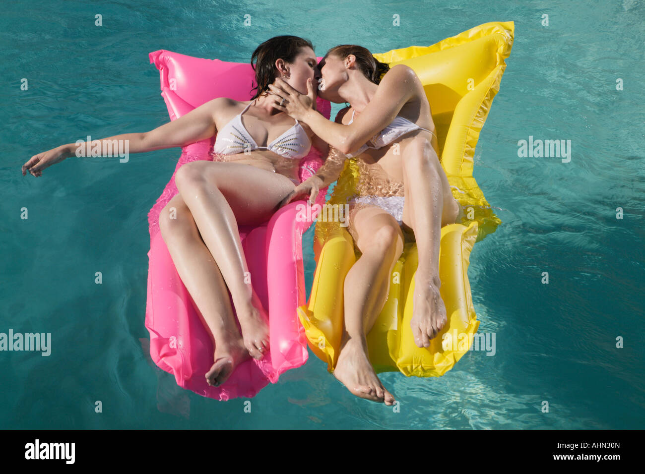 Couple de lesbiennes s'embrasser sur des radeaux en piscine Photo Stock -  Alamy