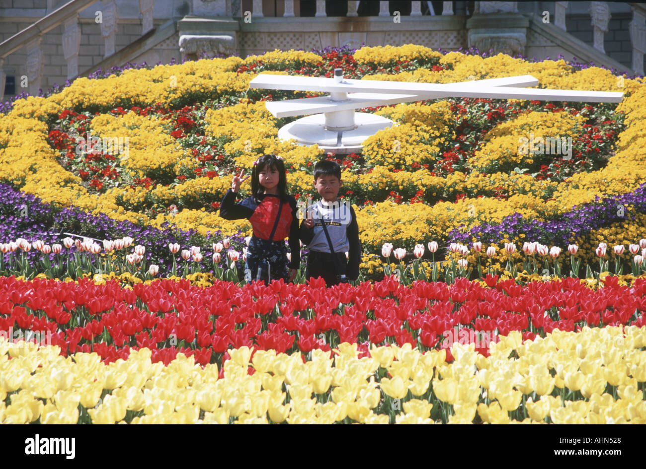 Les enfants japonais donner signe de paix à Huis ten Bosch theme park Japon Banque D'Images