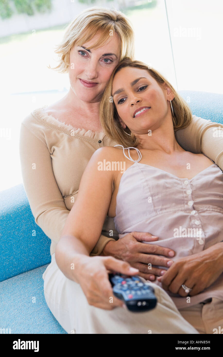 Couple de lesbiennes devant la télévision Banque D'Images