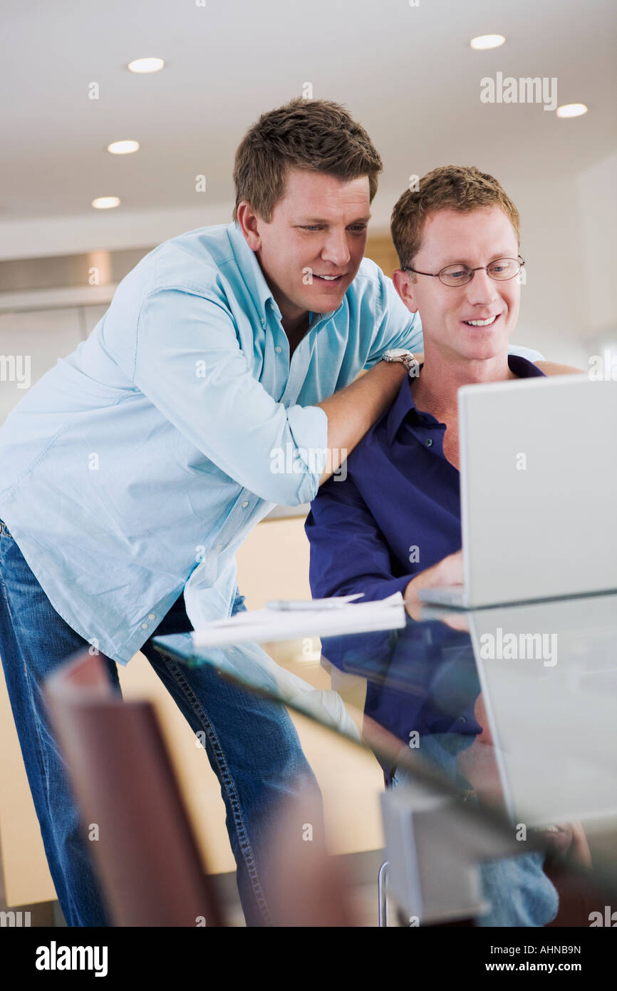 L'homme en regardant son petit ami utiliser un ordinateur Banque D'Images