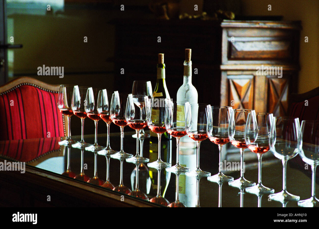 Une rangée de verres remplis de vin rose et deux bouteilles sur une table de réflexion dans la salle de dégustation, Château Puech-Haut, Saint-Drezery, Coteaux du Languedoc, Languedoc-Roussillon, France Banque D'Images