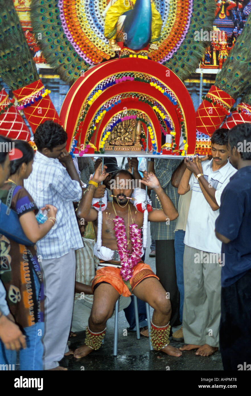 Thaipusam dévot portant un kavadi et reposant sur une chaise près de grottes de Batu Kuala Lumpur Malaisie Asie du sud-est Banque D'Images