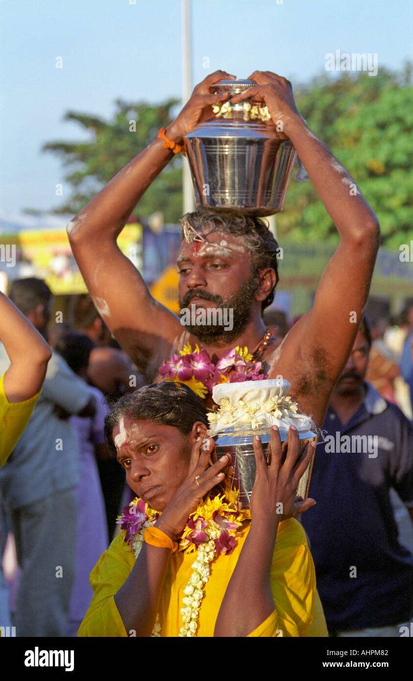 Thaipusam dévots transportant des pots remplis d'offrir du lait de coco à marcher vers les grottes de Batu Kuala Lumpur Malaisie Asie Banque D'Images