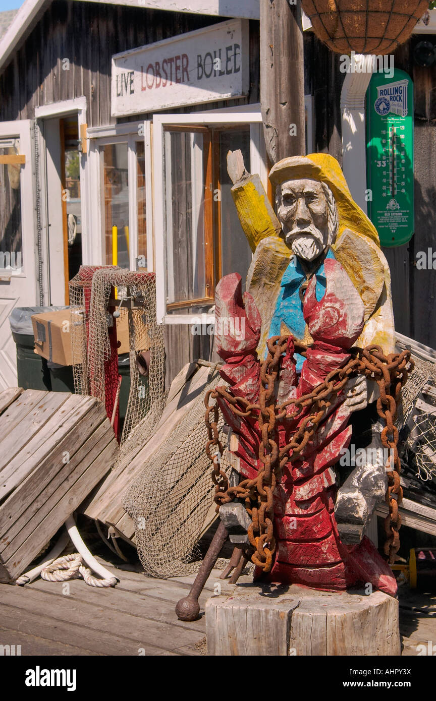 Un pêcheur en bois sculpté figure à l'extérieur d'un restaurant de fruits de mer sur un quai en Bar Harbor Maine Banque D'Images