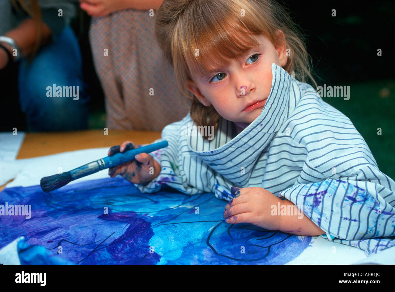Petite fille peinture avec des couleurs de l'eau Banque D'Images