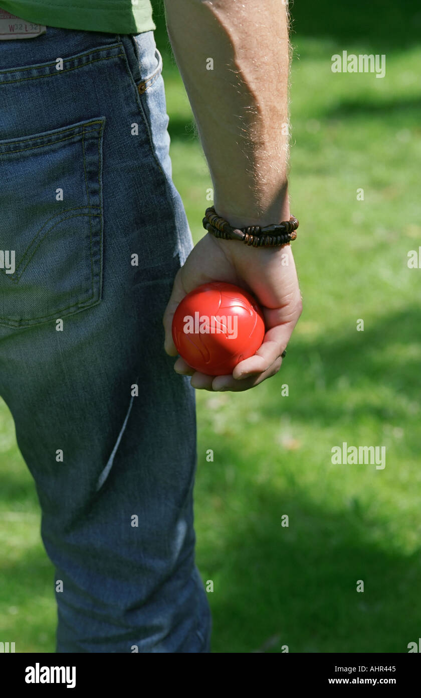Homme tenant une boule rouge dans sa main. Banque D'Images