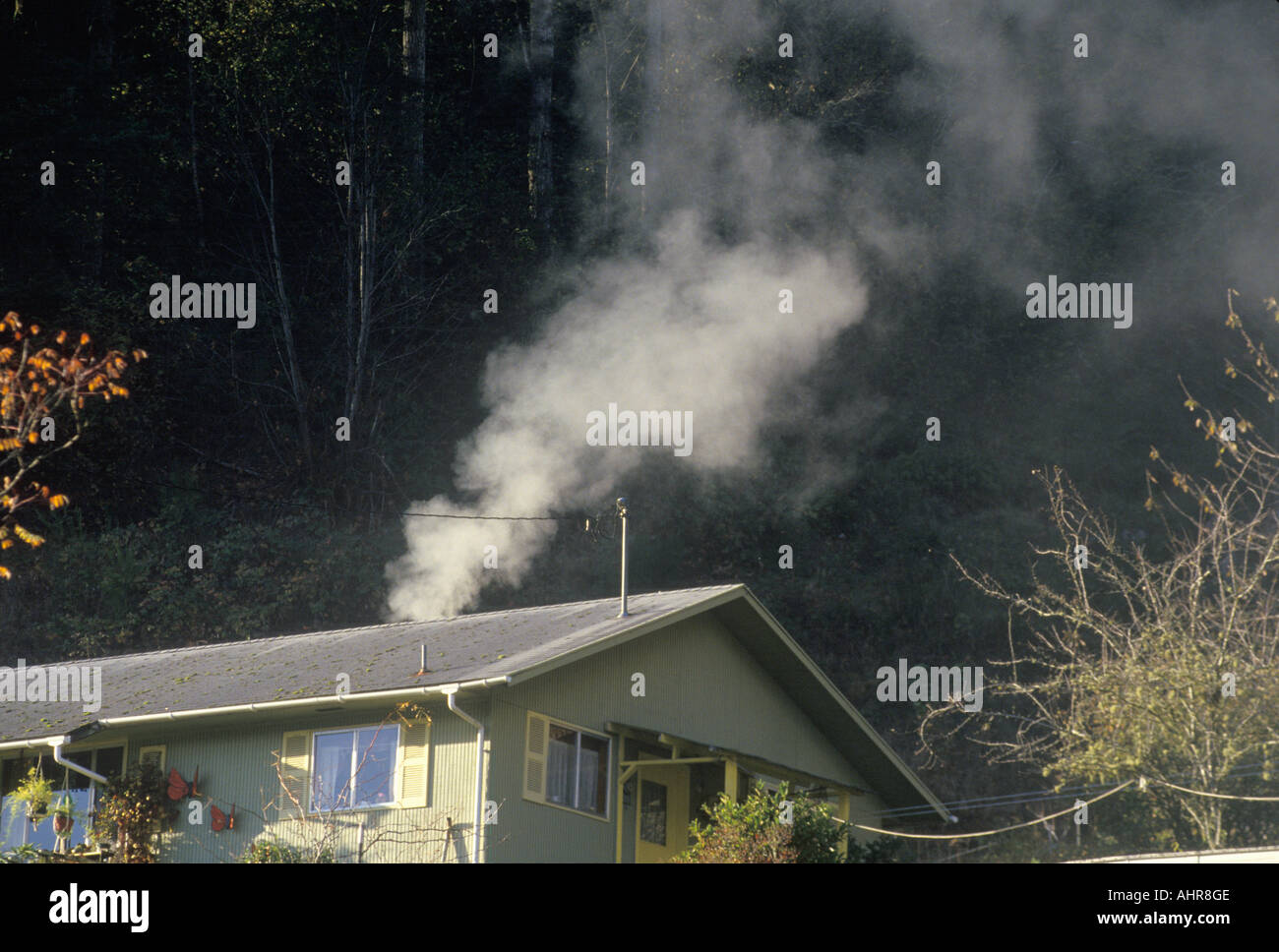 La fumée d'un poêle à bois dans une petite maison Banque D'Images