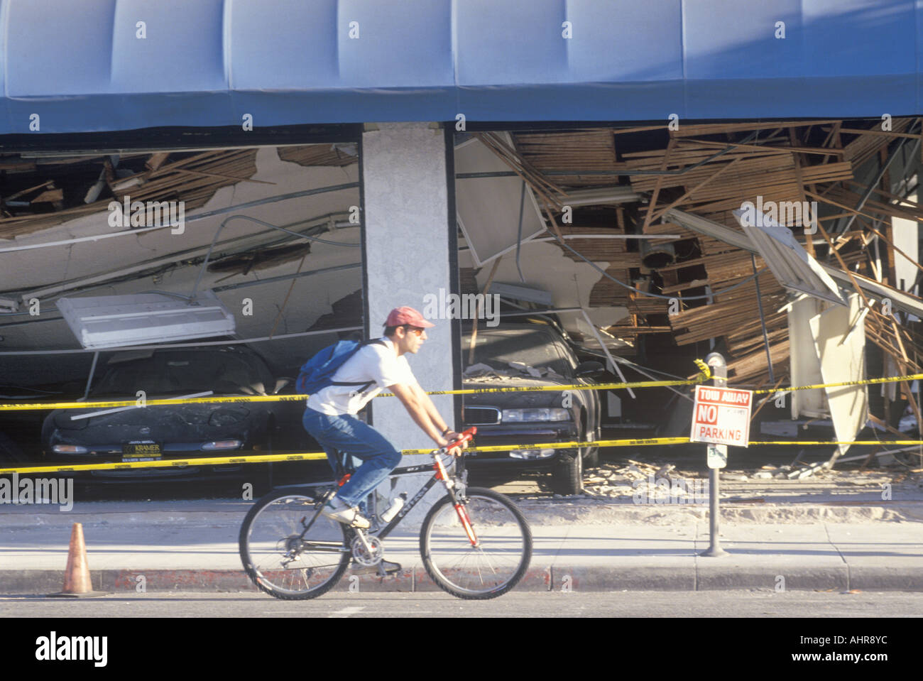 Un cycliste, équitation passé une voiture détruite de Santa Monica après le tremblement de terre de Northridge en 1994 Banque D'Images