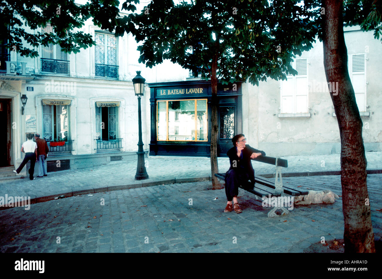 Paris France, Montmartre personnes assises sur le banc pubien, devant 'Street Scene' 'le bateau Lavoir' Picasso Studio, lampadaire de Paris Banque D'Images