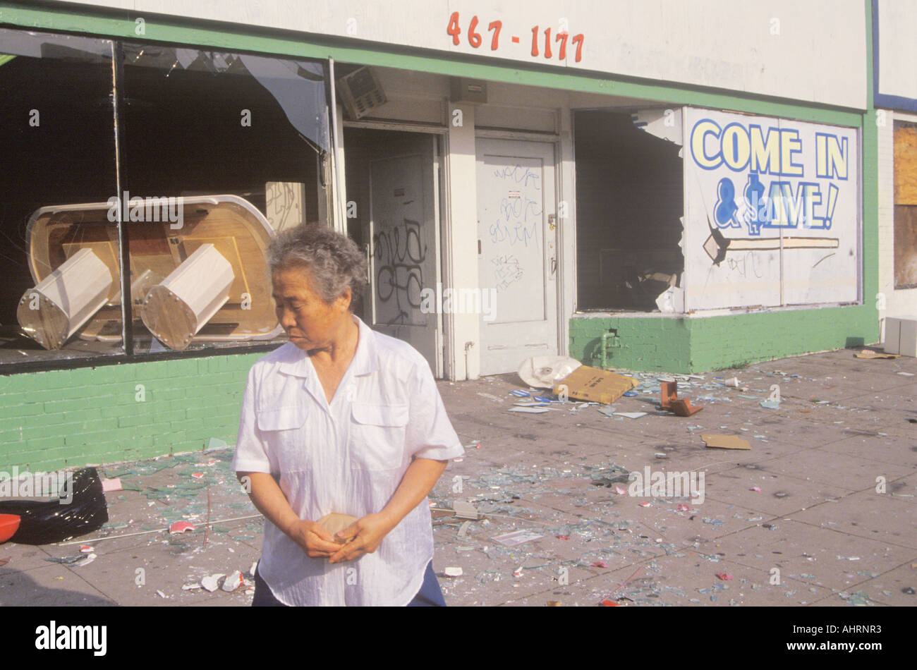 Asian woman standing in front of store pillés lors des émeutes de 1992 South Central Los Angeles California Banque D'Images