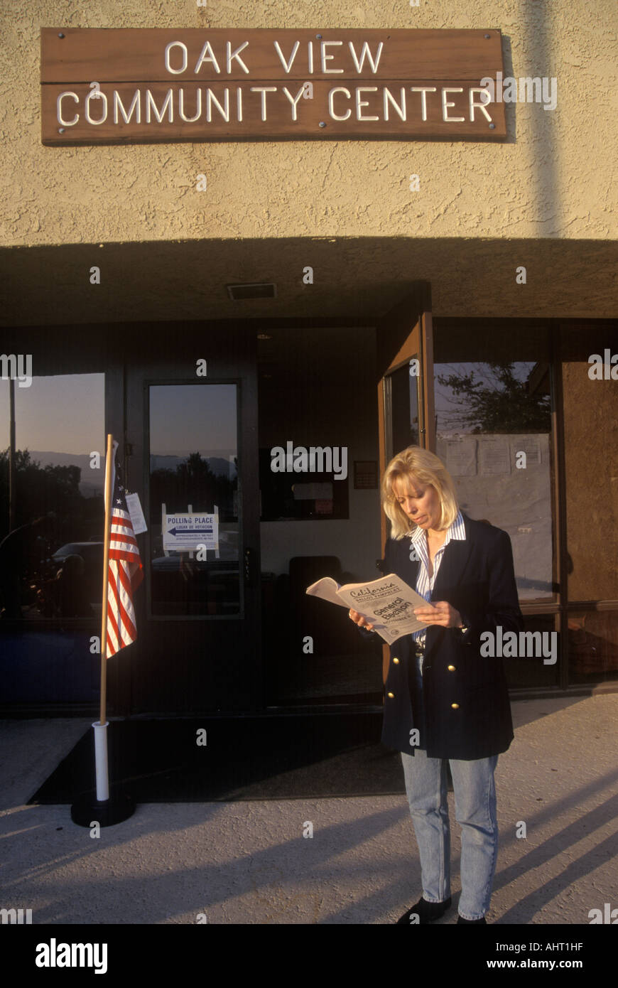 L'électeur élection femme lecture brochure à l'entrée d'un lieu de scrutin CA Banque D'Images