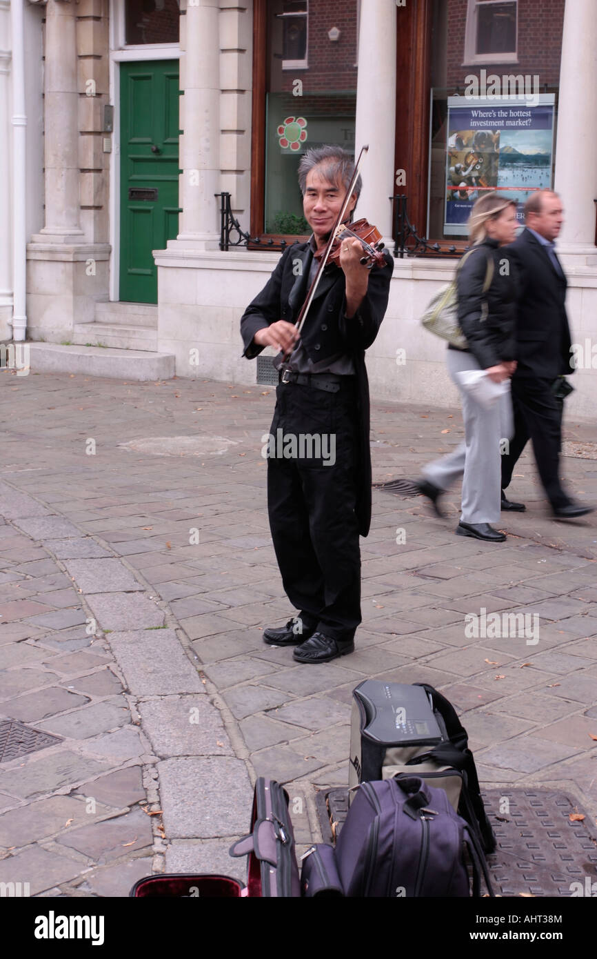 Homme adulte Busker jouant du violon dans la zone piétonne de Chichester, West Sussex, Royaume-Uni Banque D'Images