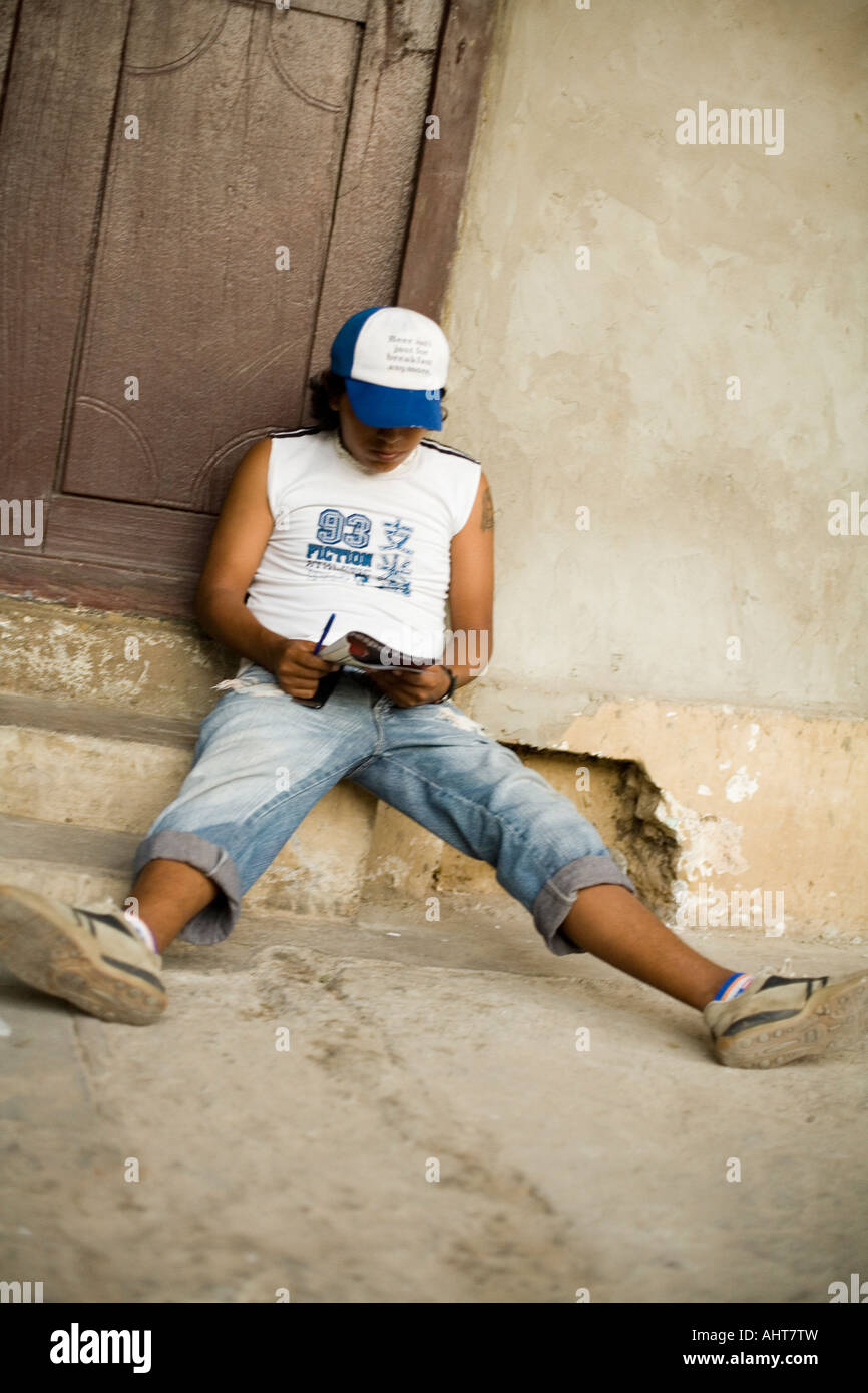 Guy faisant un jeu de mots croisés dans la rue de Santa Cruz, Bolivie Banque D'Images