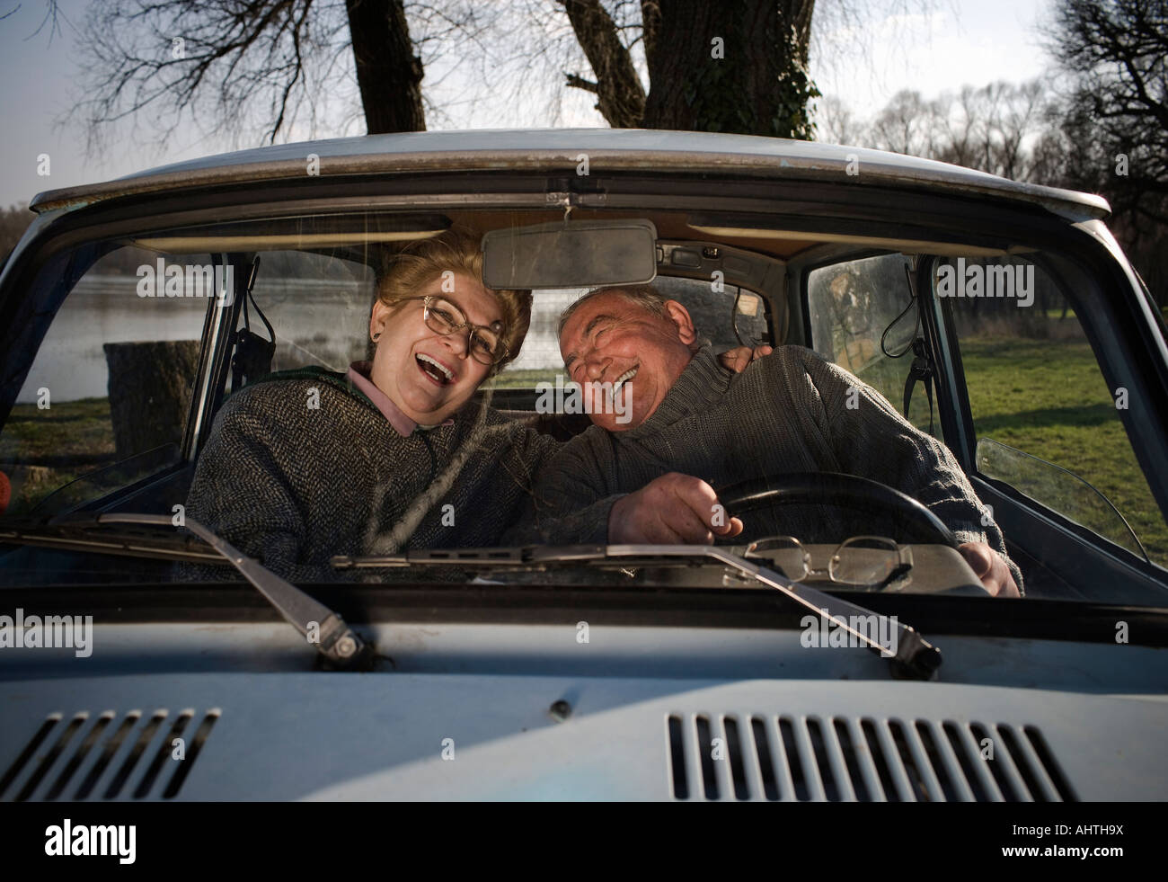 Senior couple sitting in car, à rire, à voir à travers la vitre Banque D'Images