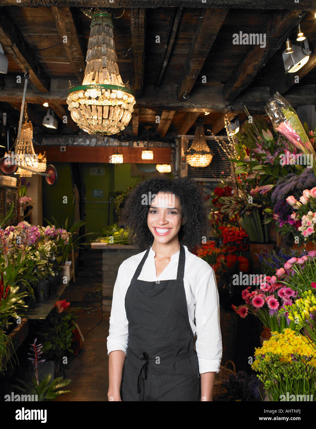 Jeune femme debout dans fleuriste shop, smiling, portrait Banque D'Images