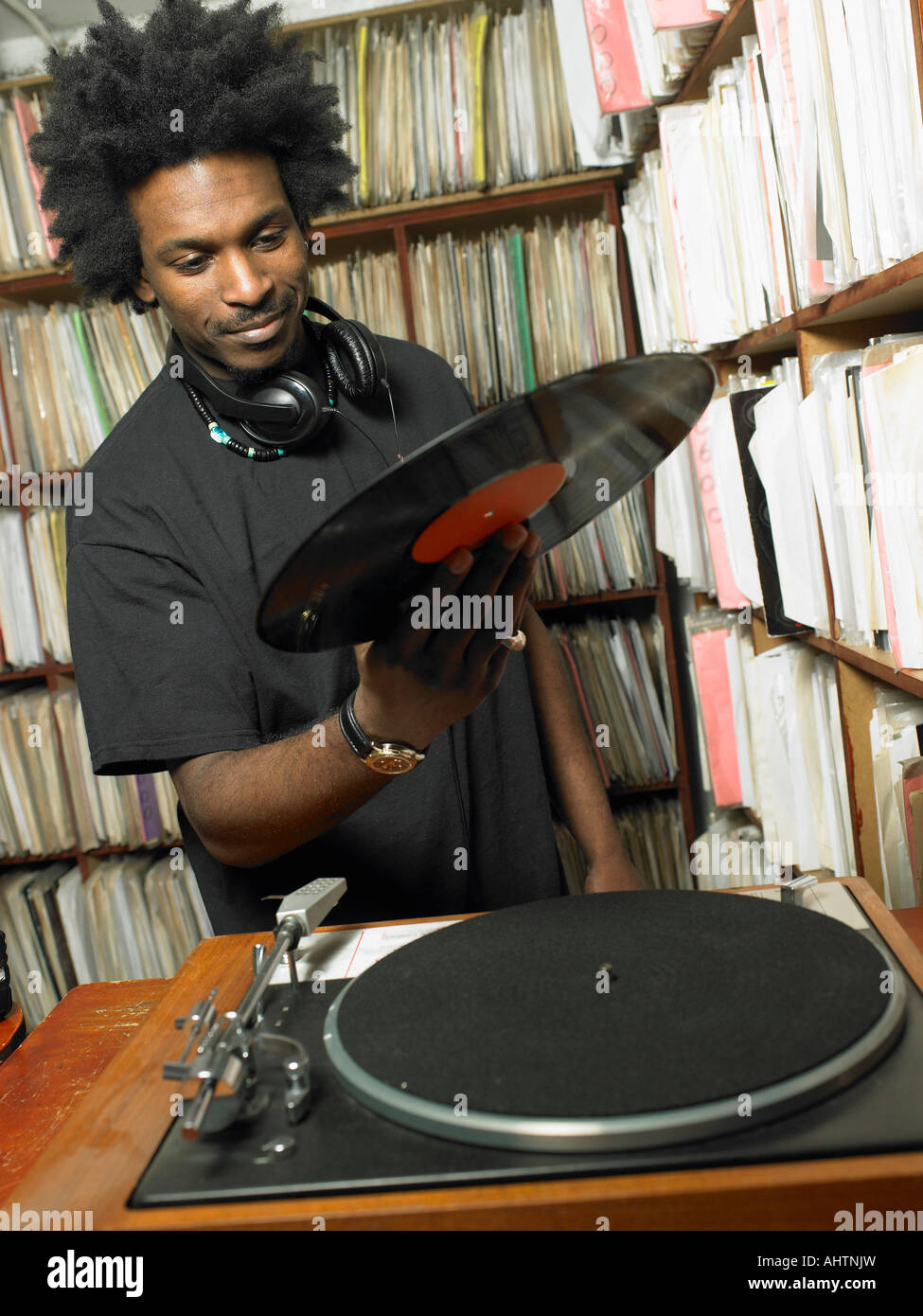 DJ mâle holding record en magasin de musique, smiling Banque D'Images