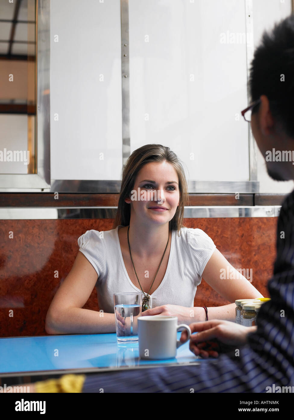 Jeune femme assise dans un café avec l'homme, smiling Banque D'Images