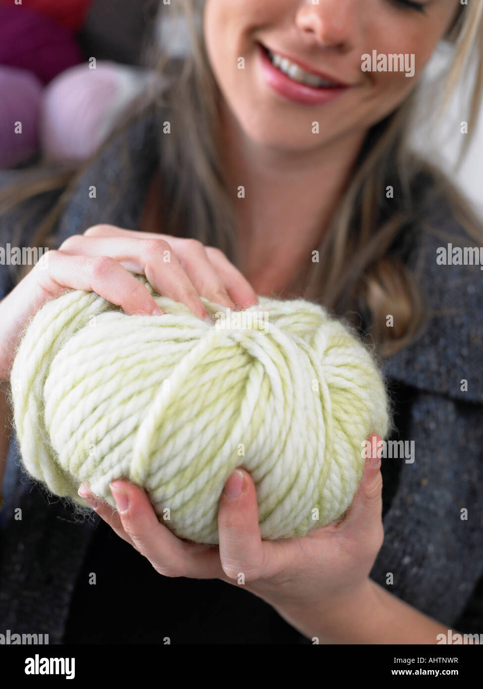 Young woman holding balle de laine, smiling, close-up Banque D'Images