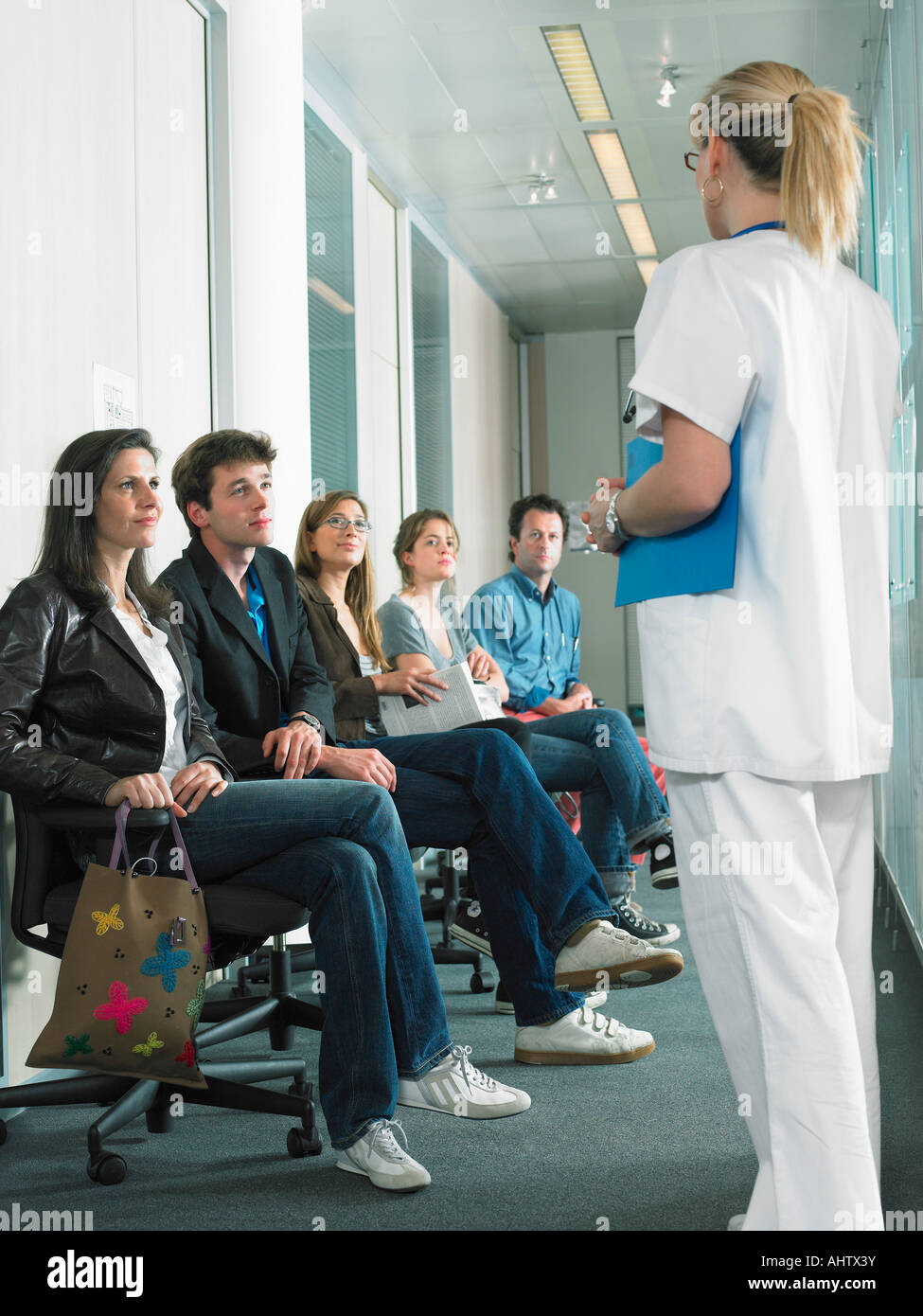 Femme médecin appelant patient suivant à l'hôpital salle d'attente. Banque D'Images