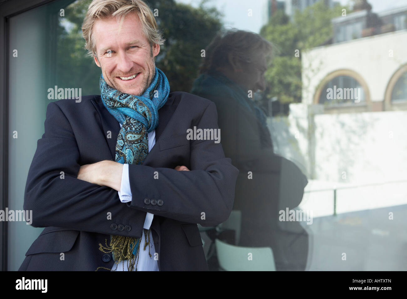 Businessman wearing scarf extravagantes appuyé contre la fenêtre. Banque D'Images