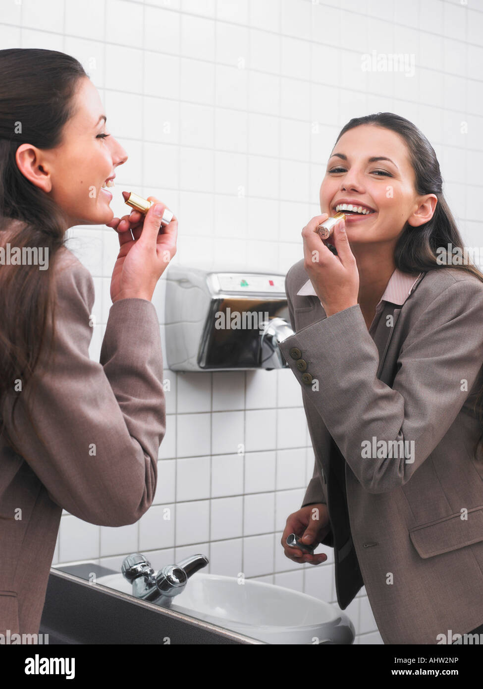 Femme reflétée dans les toilettes du bureau application miroir make-up Banque D'Images