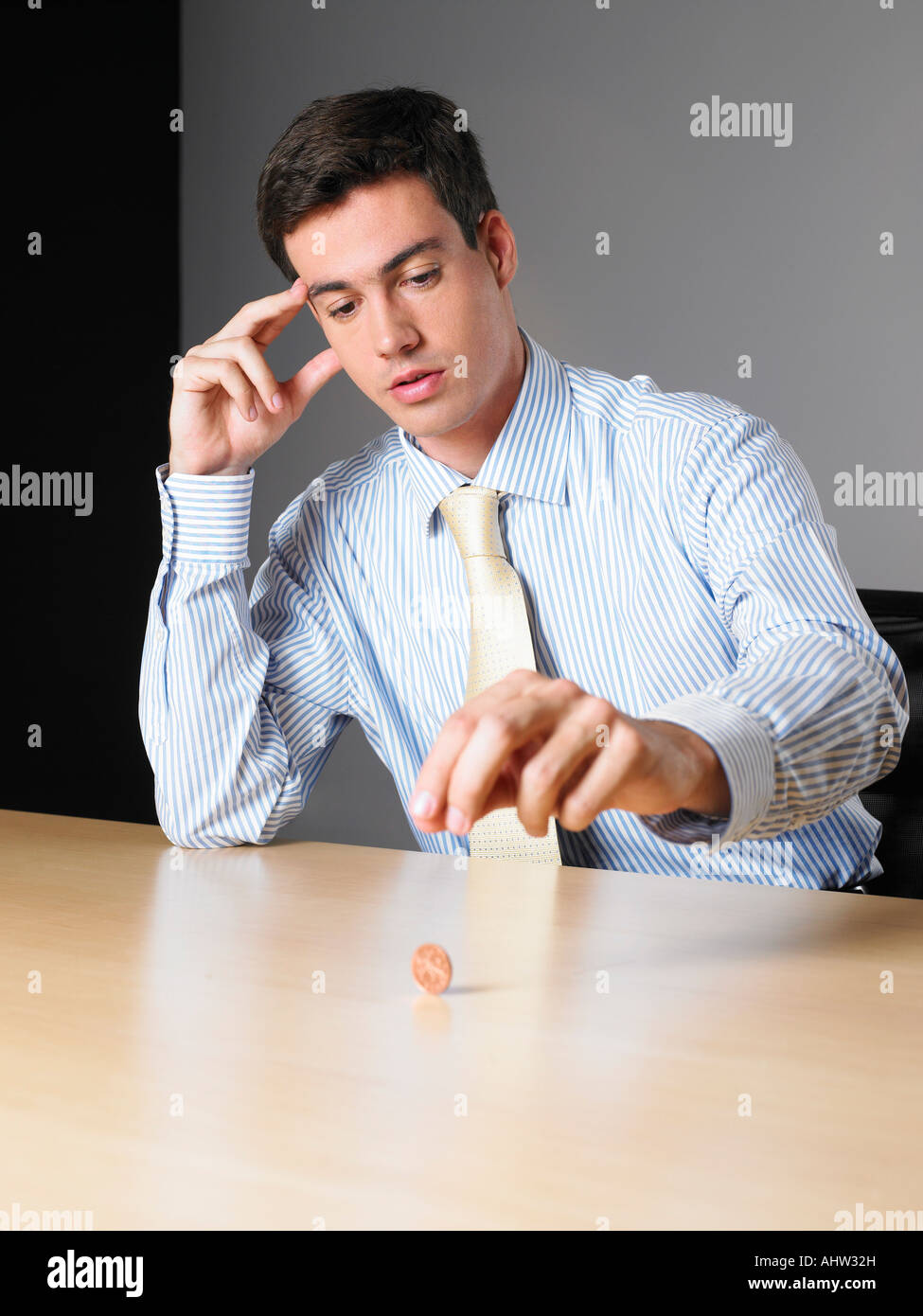 Young la rotation d'un penny sur un bureau Banque D'Images