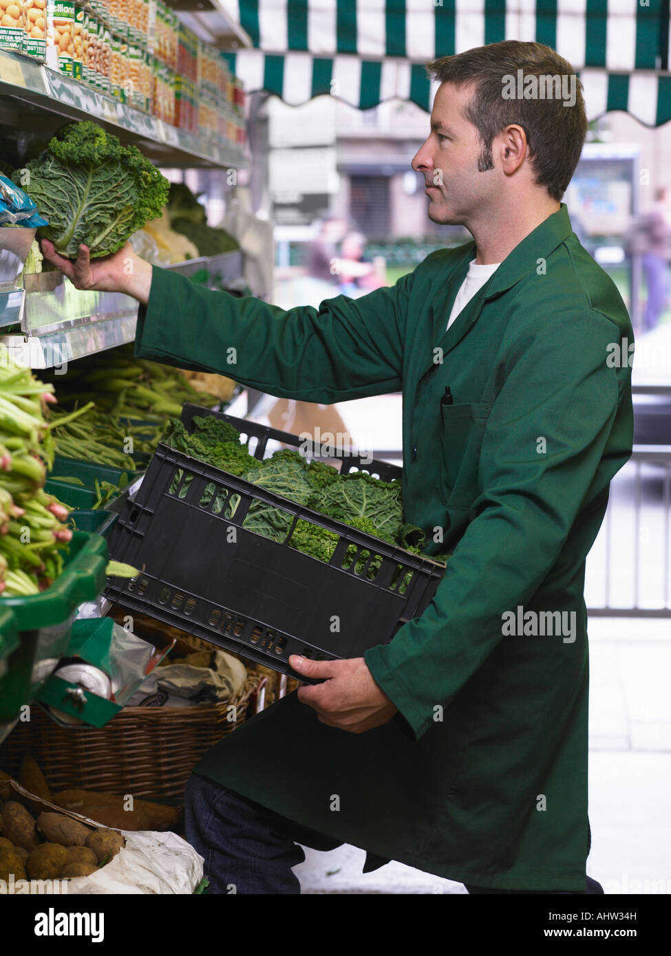 Épicerie étagères de remplissage avec des légumes Banque D'Images
