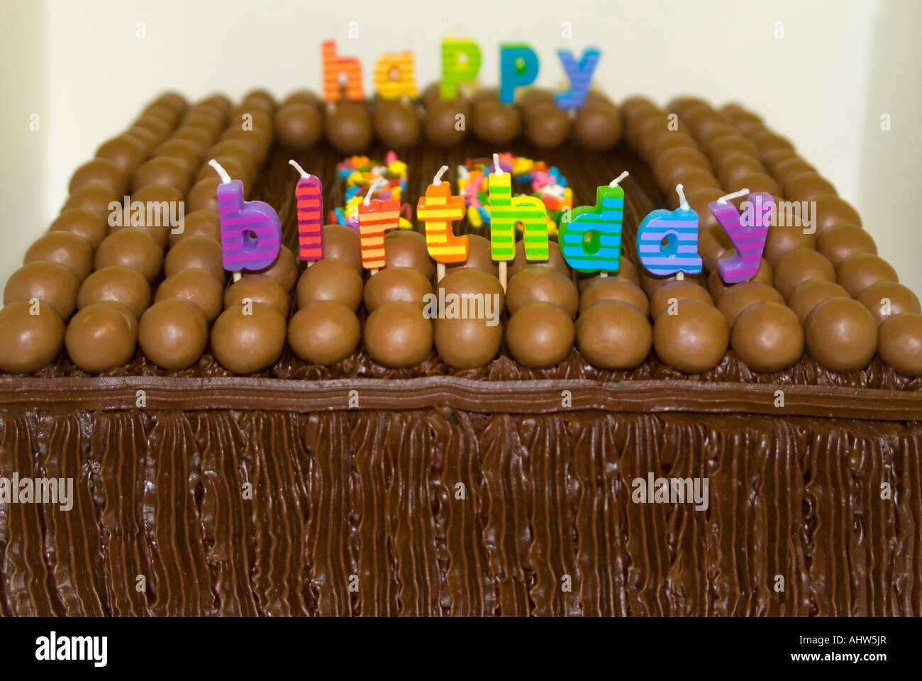 Close up of a horizontal du 10e anniversaire de l'enfant, gâteau décoré avec des bonbons au chocolat, glaçage et des bougies Banque D'Images
