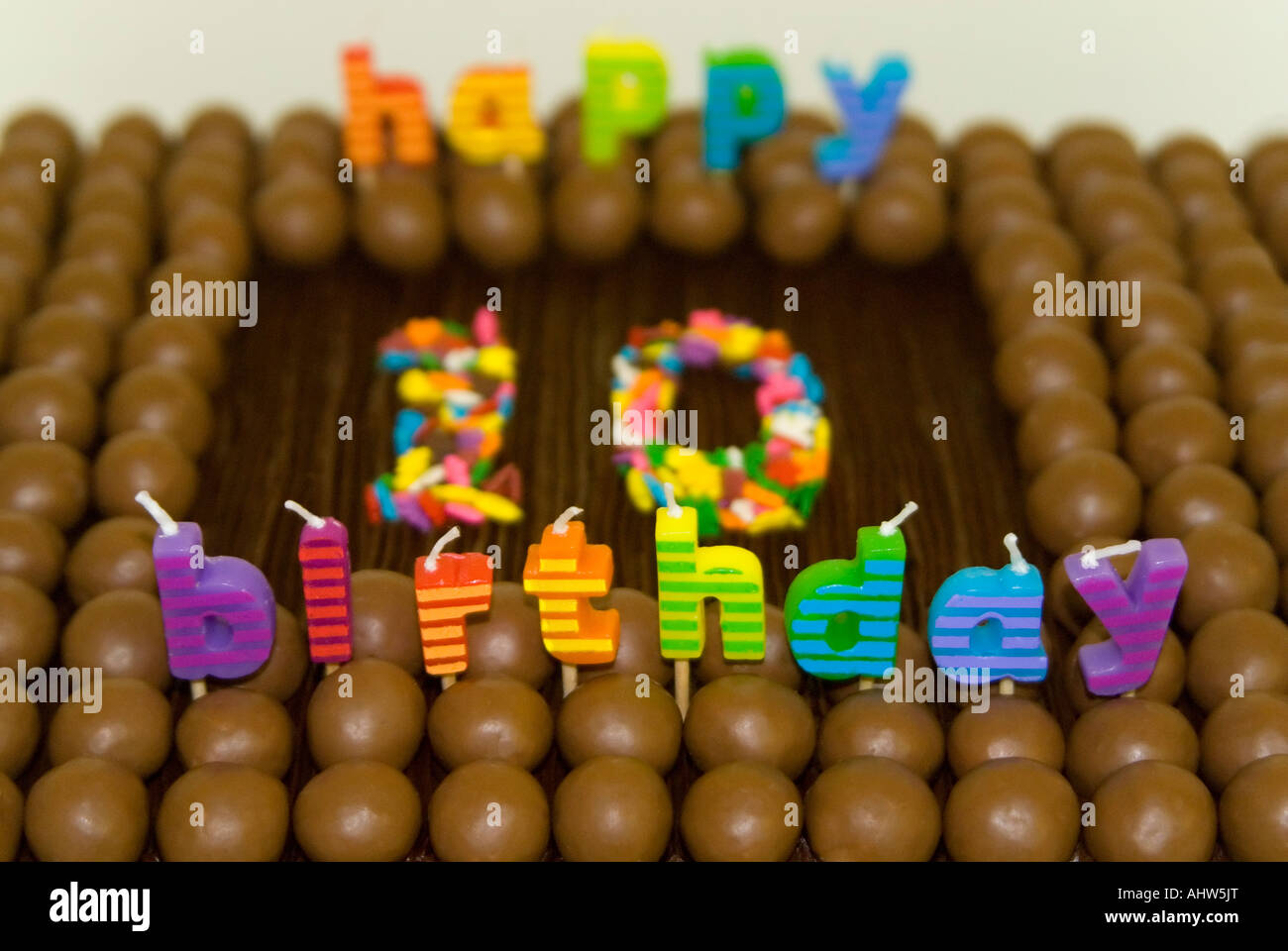 Close up of a horizontal du 10e anniversaire de l'enfant, gâteau décoré avec des bonbons au chocolat, glaçage et des bougies Banque D'Images