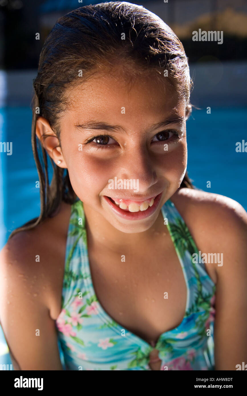 Belle petite fille d'Amérique latine en maillot au bord de la piscine Banque D'Images